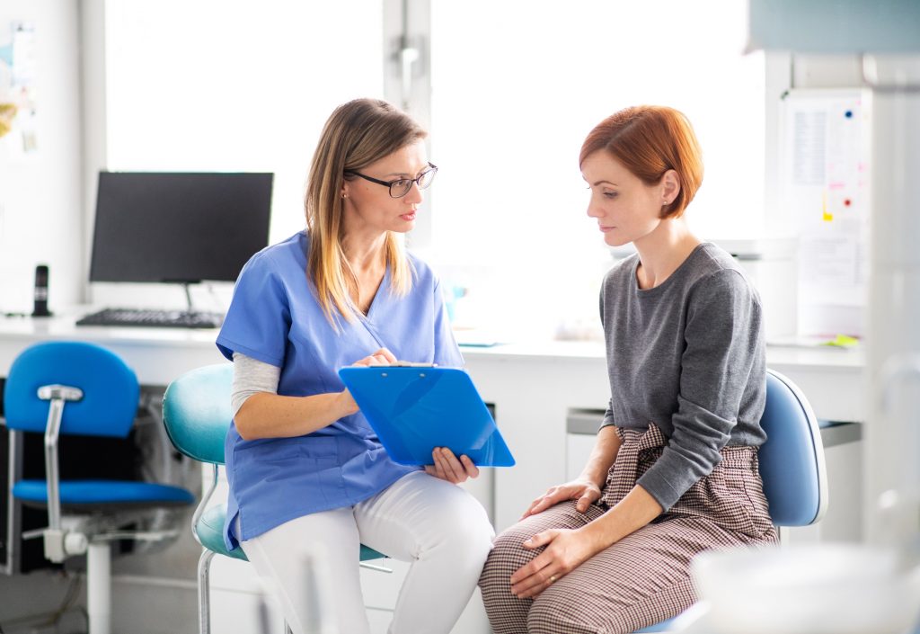 woman doctor talking to a woman patient in an exam room